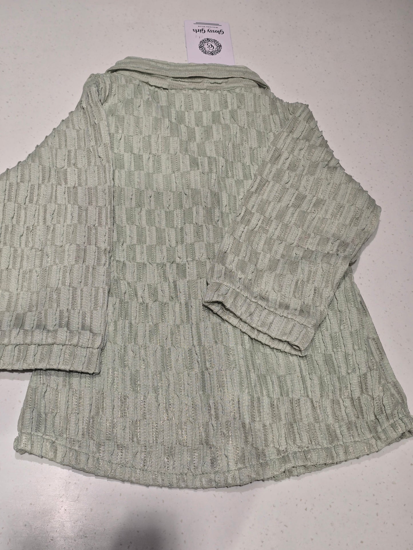 light sage green textured top/cardigan featuring a distinctive puckered or "popcorn" brick-weave pattern