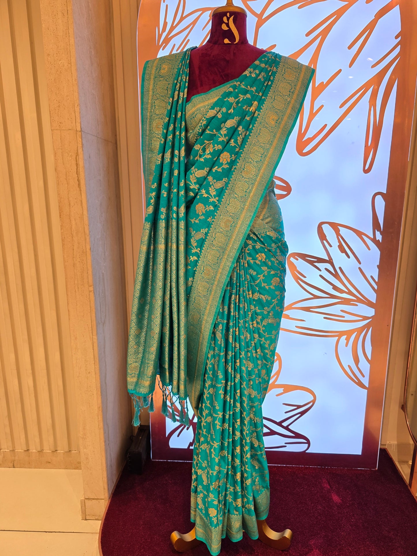 traditional turquoise Banarasi silk saree featuring intricate gold zari floral vines and a broad,