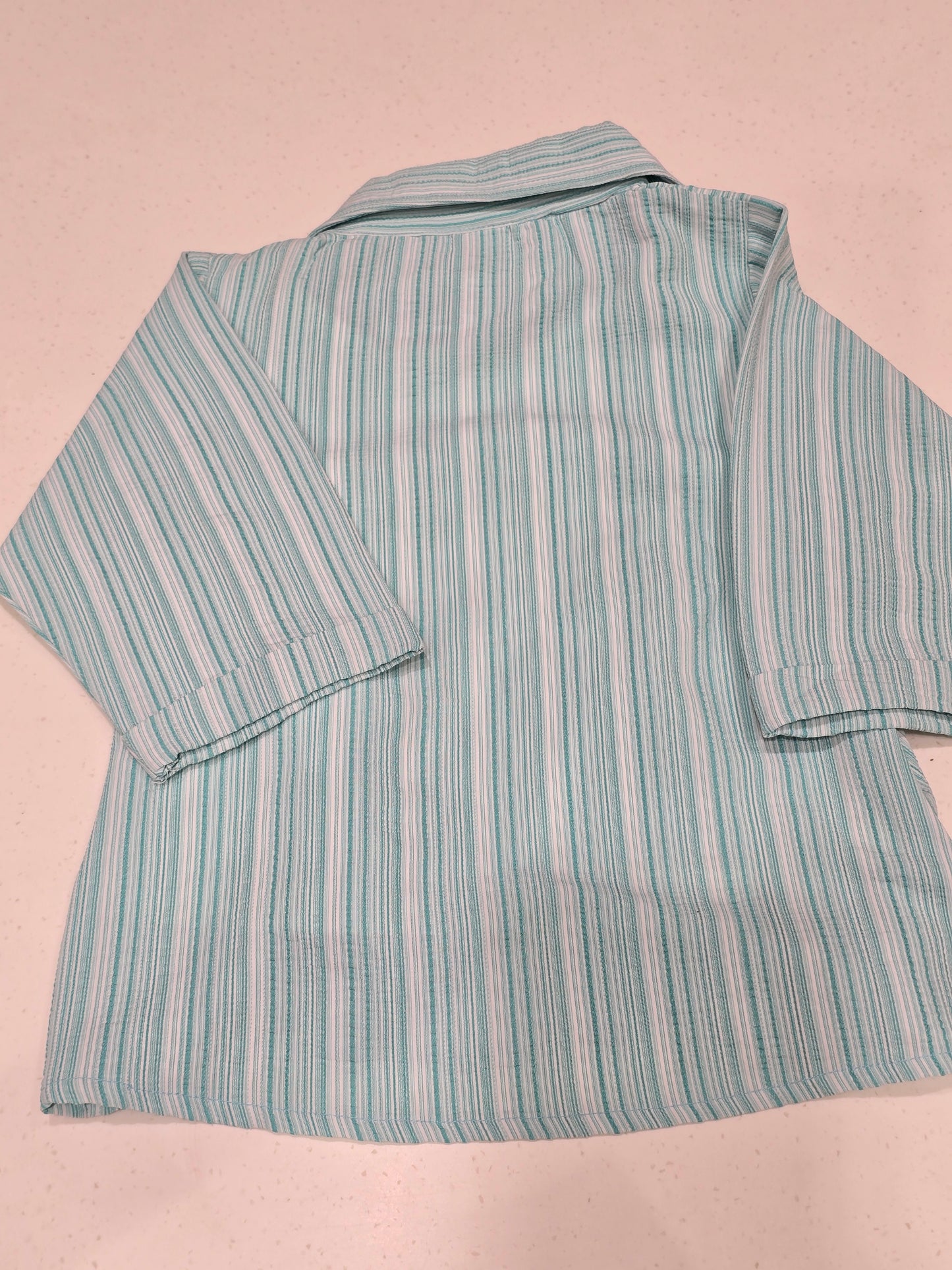 casual matching set featuring a green-and-white vertically striped button-down shirt layered over a white graphic t-shirt with text reading