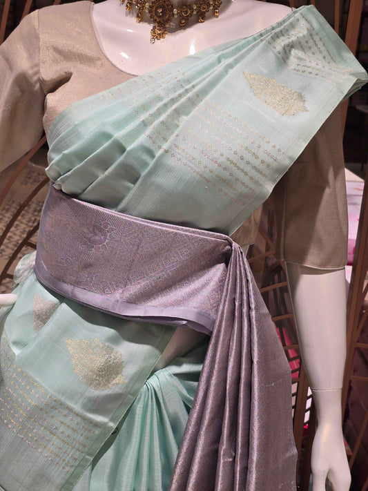 pastel mint green traditional silk saree styled with a contemporary contrasting lavender-grey fabric waist belt (kammarbandh) and an elegant,