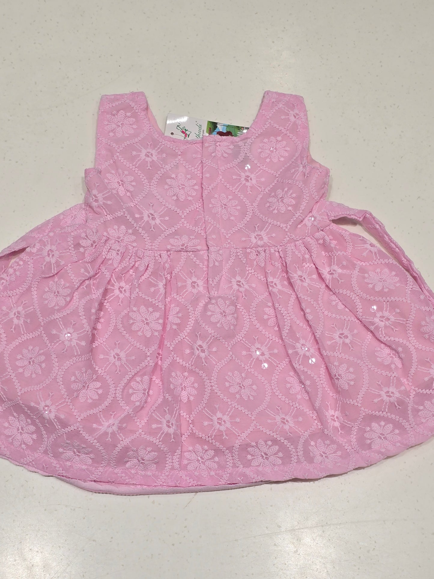baby girl's cotton frock in a soft pastel pink shade.