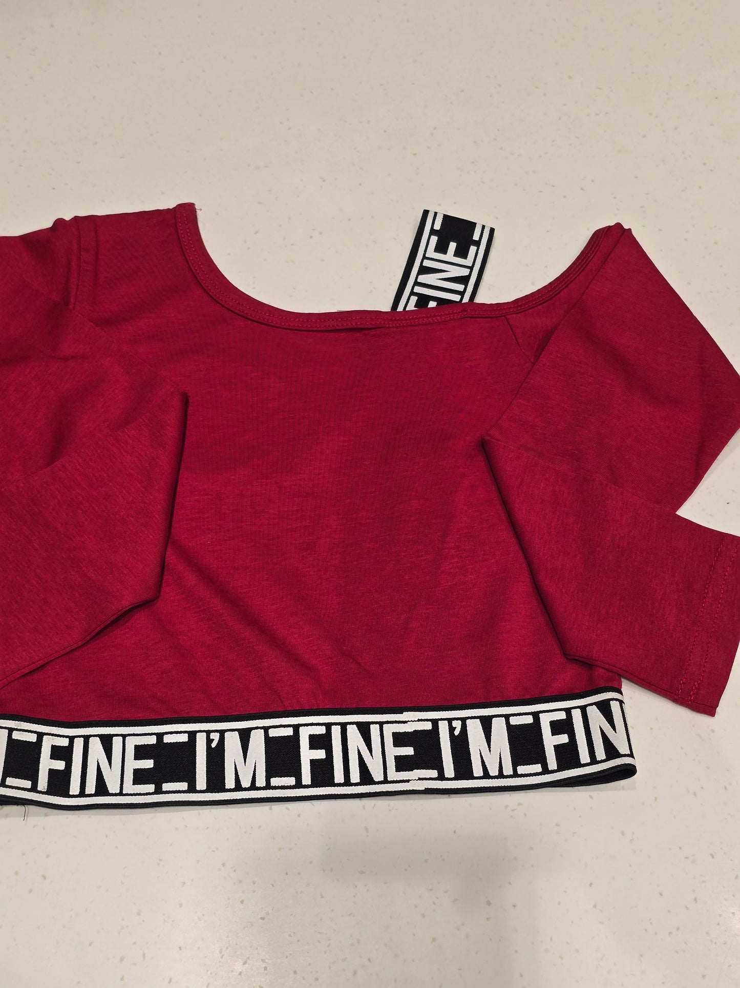 maroon/dark red off-shoulder long-sleeve crop top designed with activewear or streetwear styling