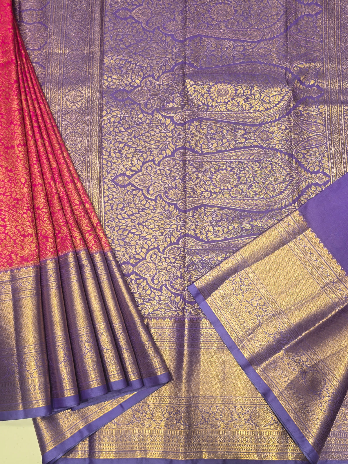 semi silk saree featuring a vibrant magenta body accented by a deep violet or purple contrast border.