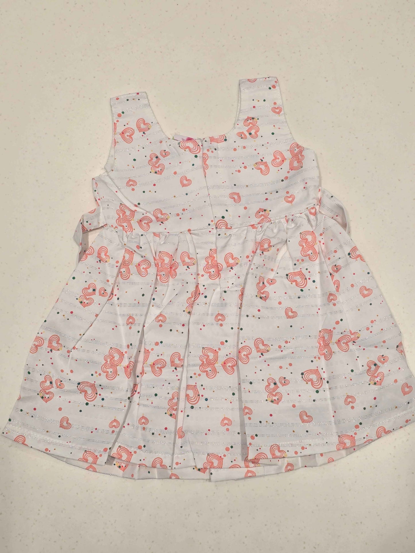 sleeveless cotton baby frock features an all-over heart print, making it perfect for everyday casual summer wear