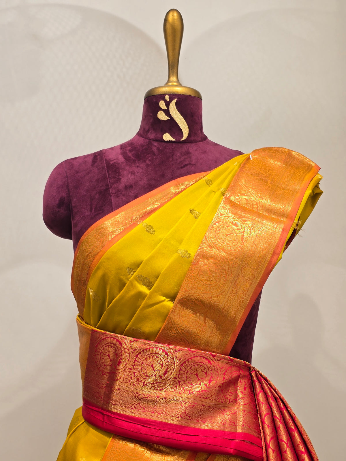 pure Kanjivaram silk saree rendered in a vibrant mustard yellow and contrasting rani pink color scheme.