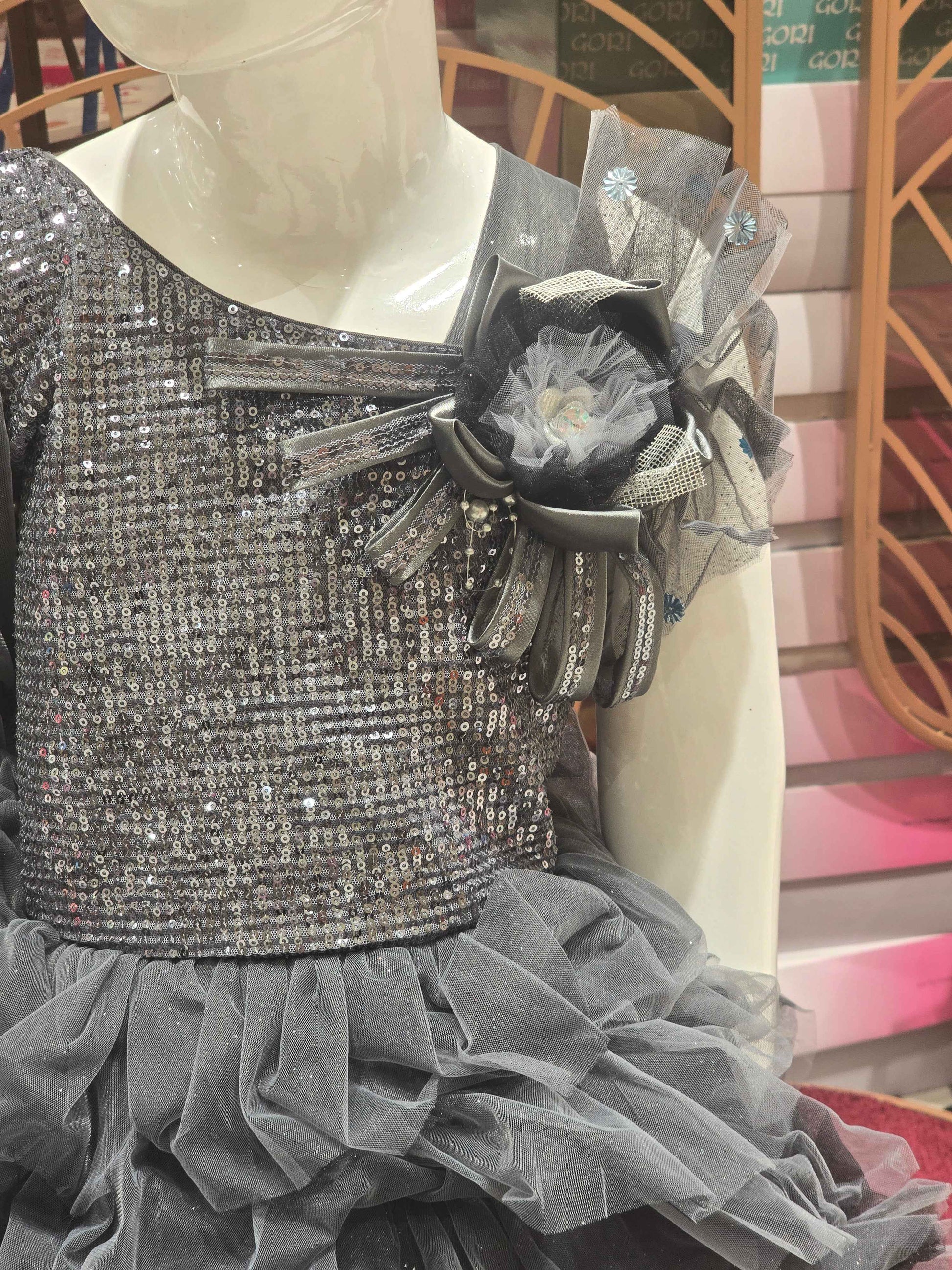 Knitted material grayish coloured short frock for baby girl with talecut pattren and sequence work over the top ,bow on left shoulder