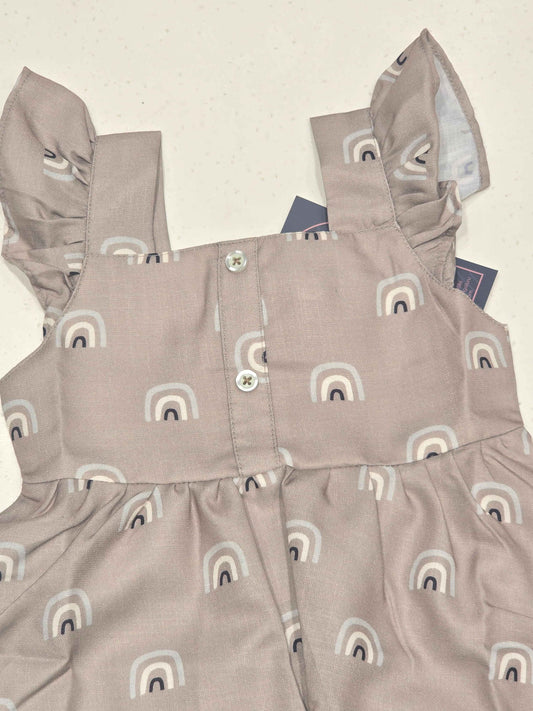 baby girl’s sleeveless cotton frock featuring a flared skirt, a gathered waist, square neckline, shoulder flutter ruffles, and a button-down back closure. It