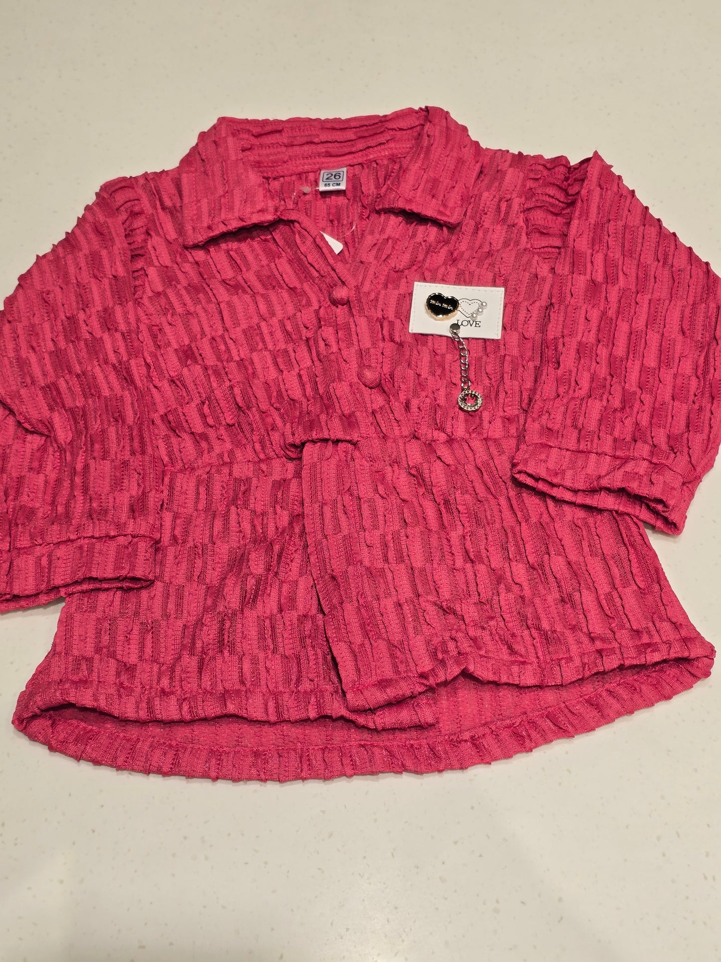 pink, crimp-textured button-down shirt featuring a cinched elastic waist belt, a spread collar,