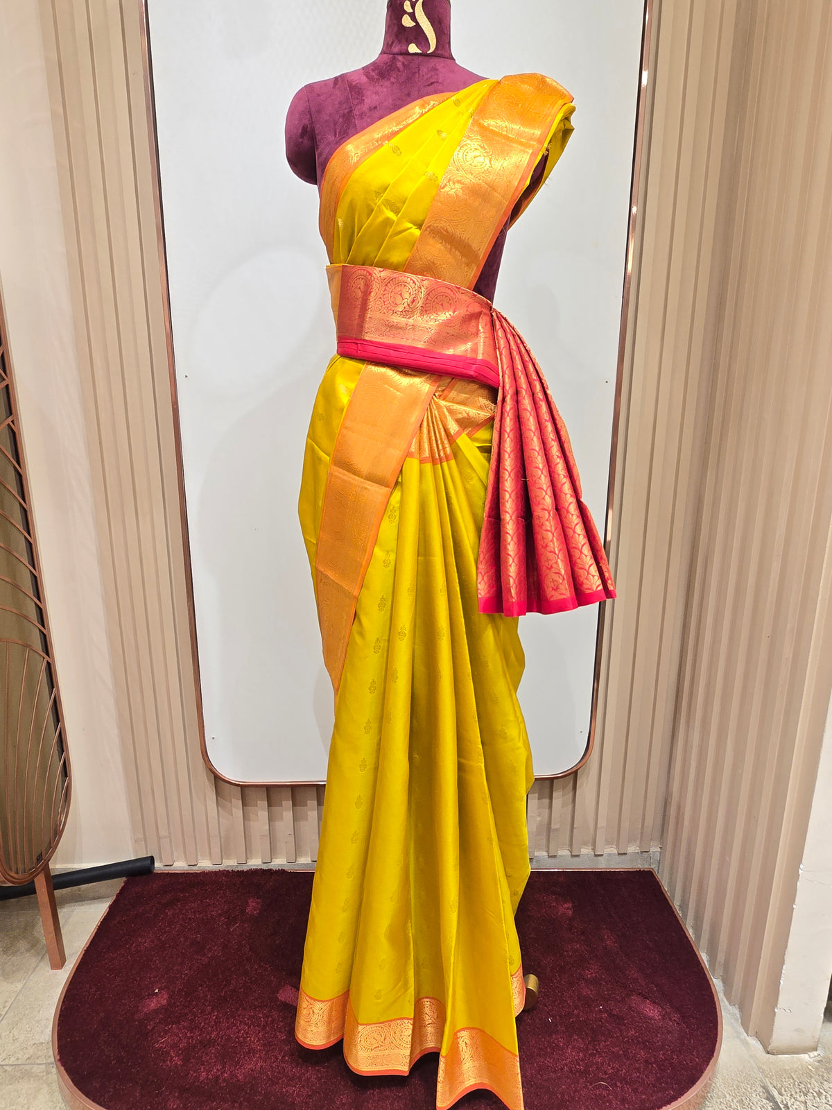 pure Kanjivaram silk saree rendered in a vibrant mustard yellow and contrasting rani pink color scheme.