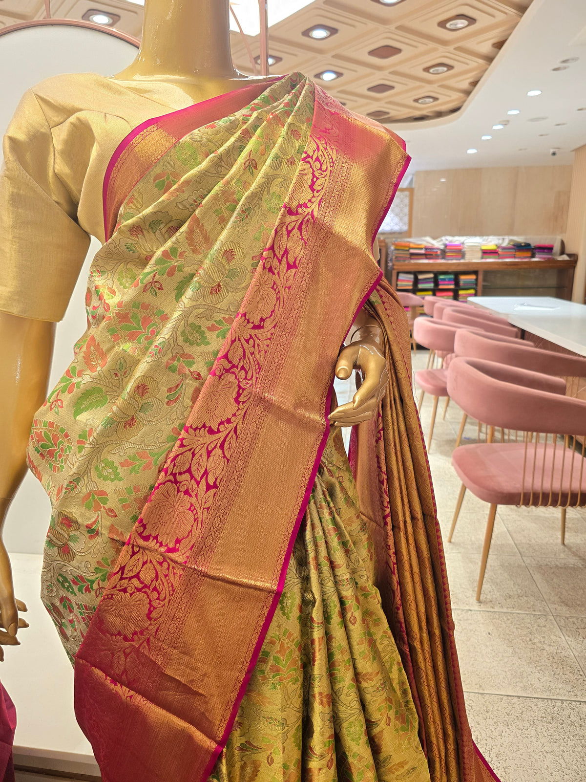 traditional Indian silk saree featuring intricate floral motifs throughout the body and a contrasting magenta-pink zari border.