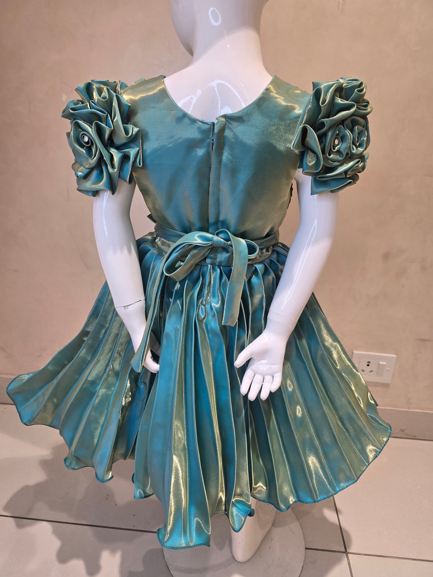 Shining Satin material green colored short frock with cold buff Sleeves , attached waist flower design