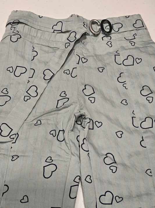 A pair of light gray patterned trousers featuring an all-over heart print,