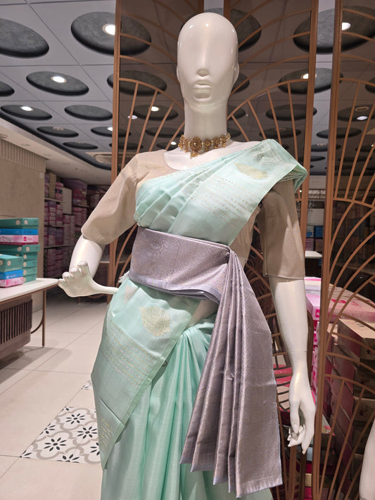 pastel mint green traditional silk saree styled with a contemporary contrasting lavender-grey fabric waist belt (kammarbandh) and an elegant,