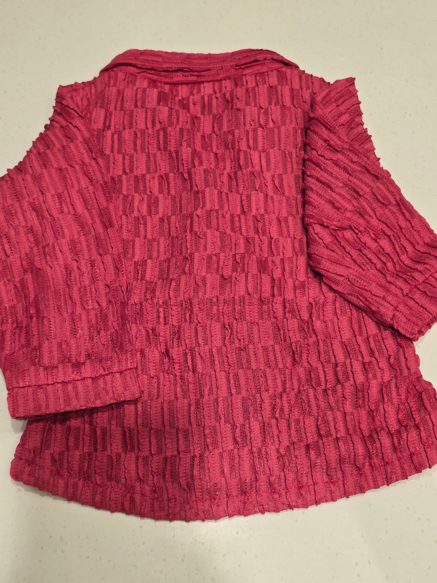 pink, crimp-textured button-down shirt featuring a cinched elastic waist belt, a spread collar,