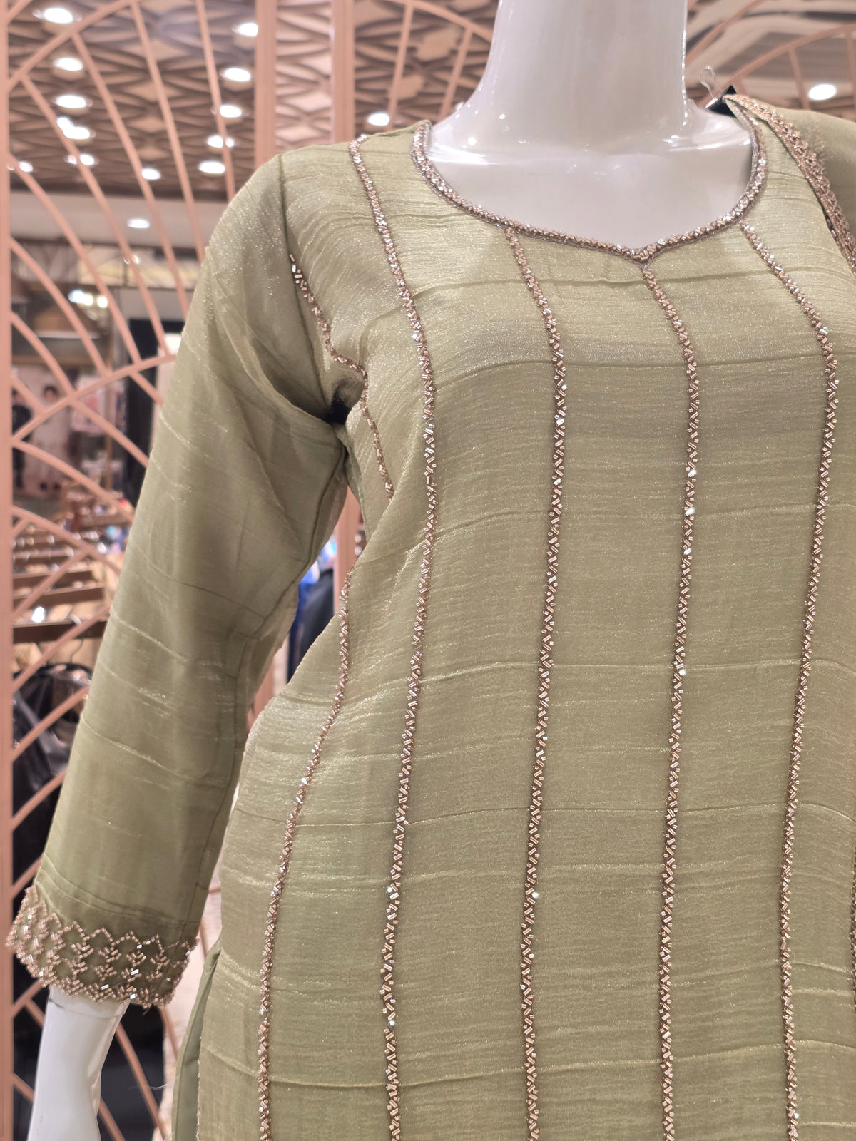 olive green ethnic salwar suit styled with subtle vertical shimmer stripes and delicate beadwork along the seams.