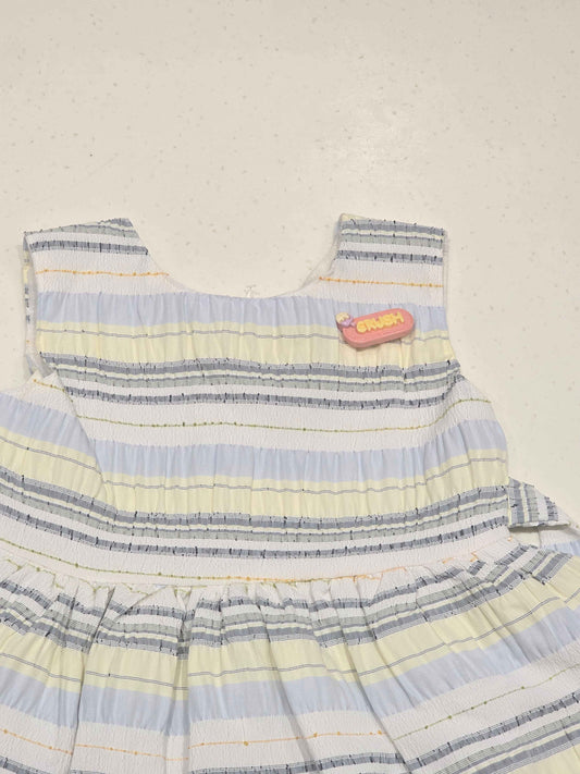 Bodice: Features an upper sleeveless cut with a rounded neckline, structured horizontal paneling, and an embroidered text patch detail on the upper left chest.