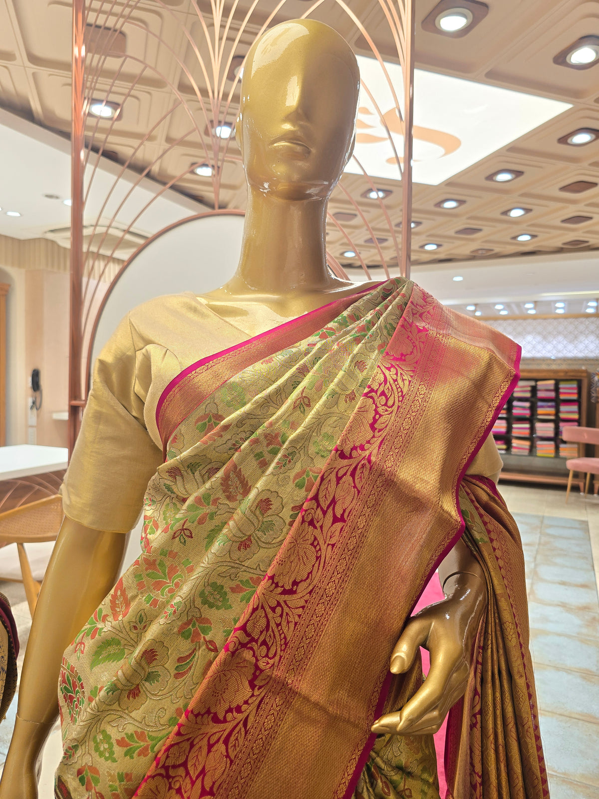 traditional Indian silk saree featuring intricate floral motifs throughout the body and a contrasting magenta-pink zari border.