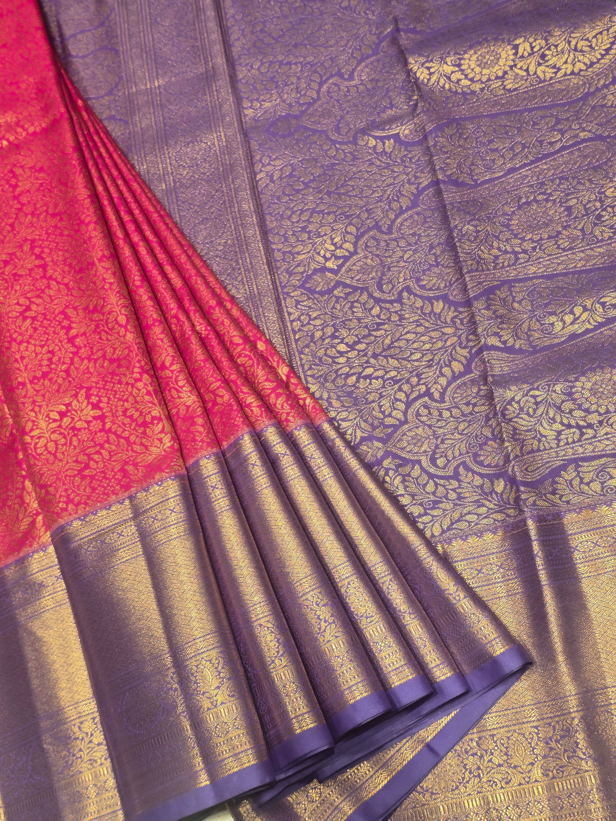 semi silk saree featuring a vibrant magenta body accented by a deep violet or purple contrast border.