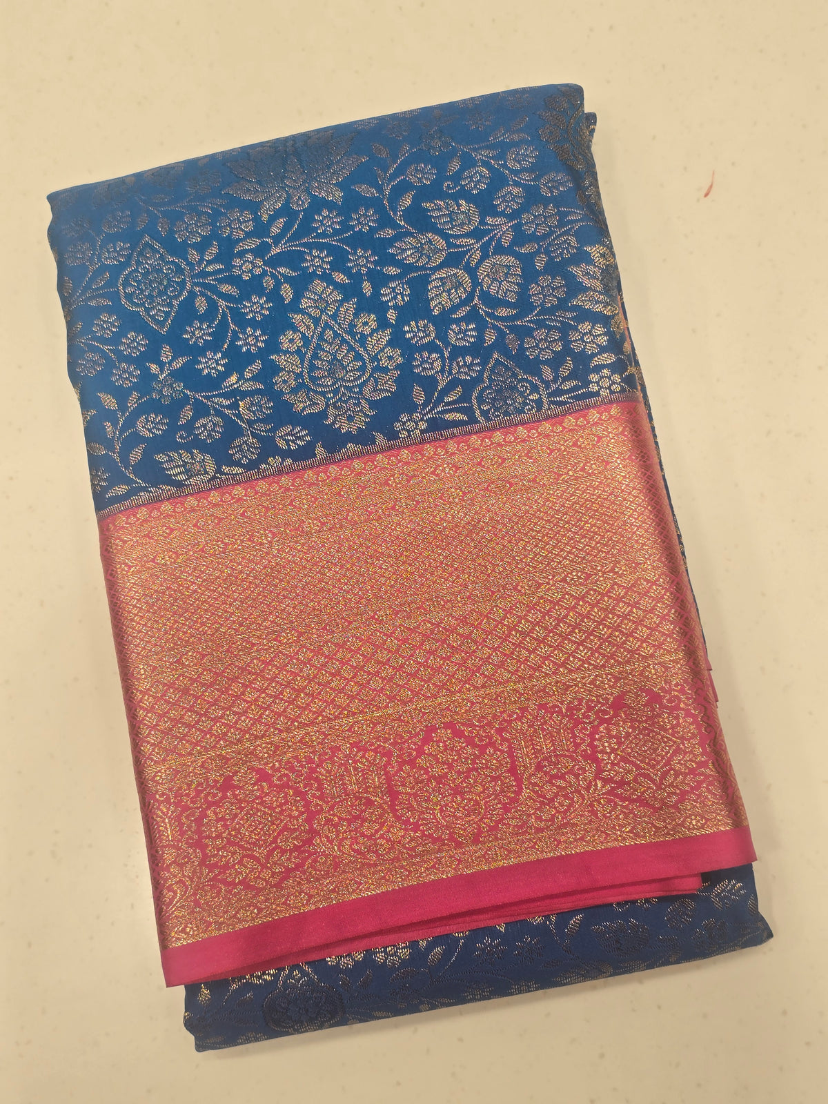 royal blue and rani pink semi-silk saree featuring rich gold zari brocade weaving.
