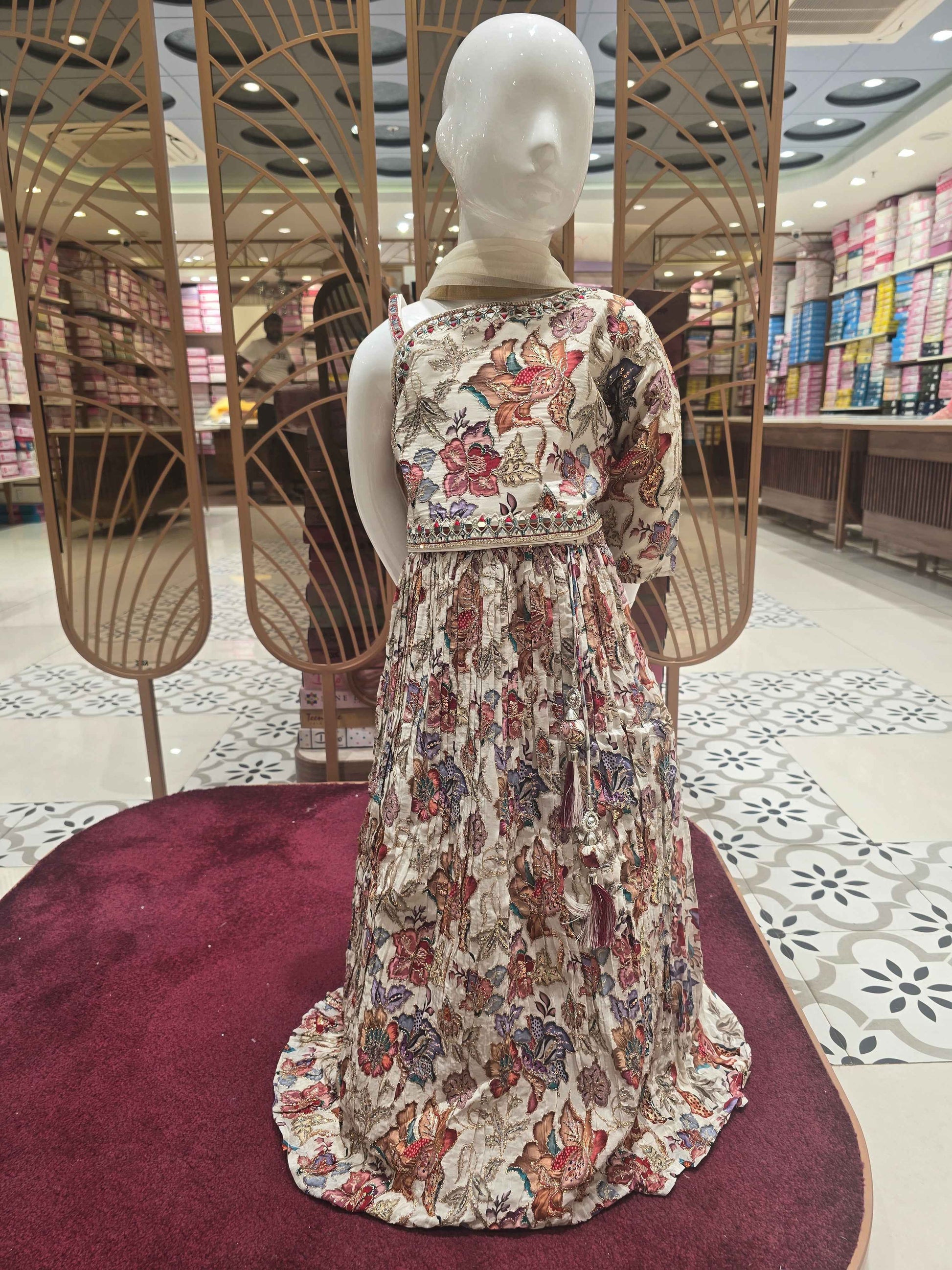 Crepe material cream based gaghra with printed floral & zari work over the body. Right shoulder with speghetti left had full sleeves