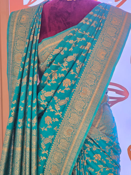 traditional turquoise Banarasi silk saree featuring intricate gold zari floral vines and a broad,