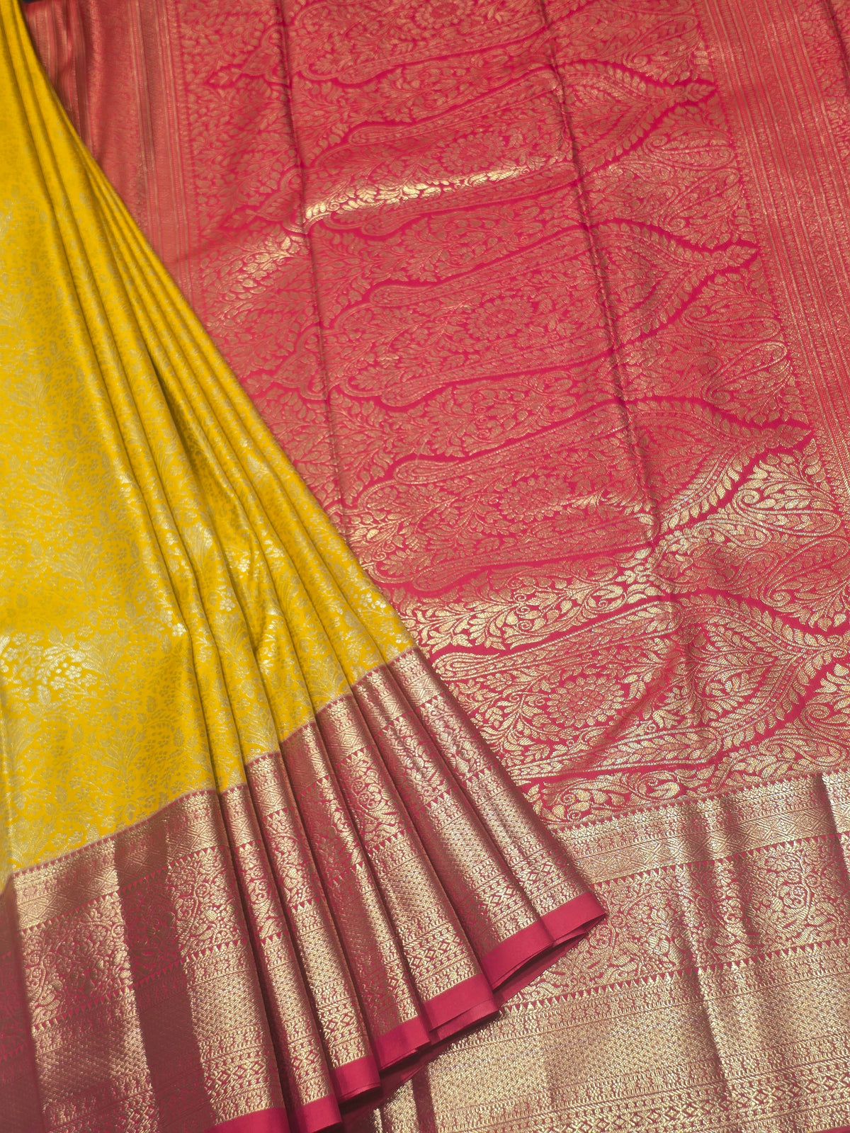 yellow and pink Kanchipuram style semi-silk saree adorned with elegant zari floral patterns and a broad contrast border.