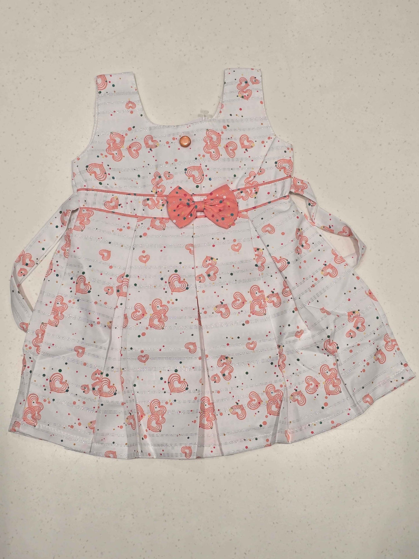 sleeveless cotton baby frock features an all-over heart print, making it perfect for everyday casual summer wear