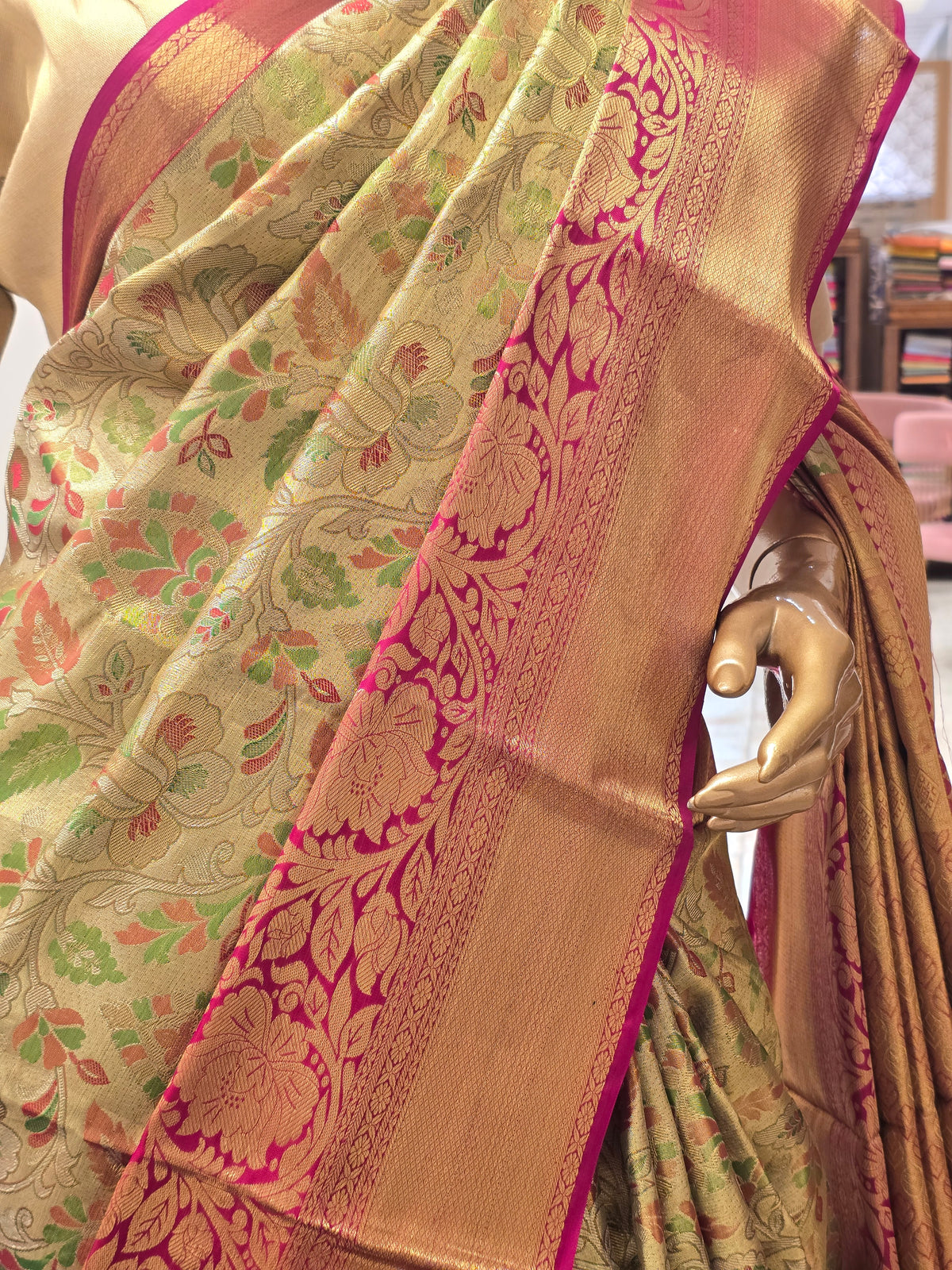 traditional Indian silk saree featuring intricate floral motifs throughout the body and a contrasting magenta-pink zari border.