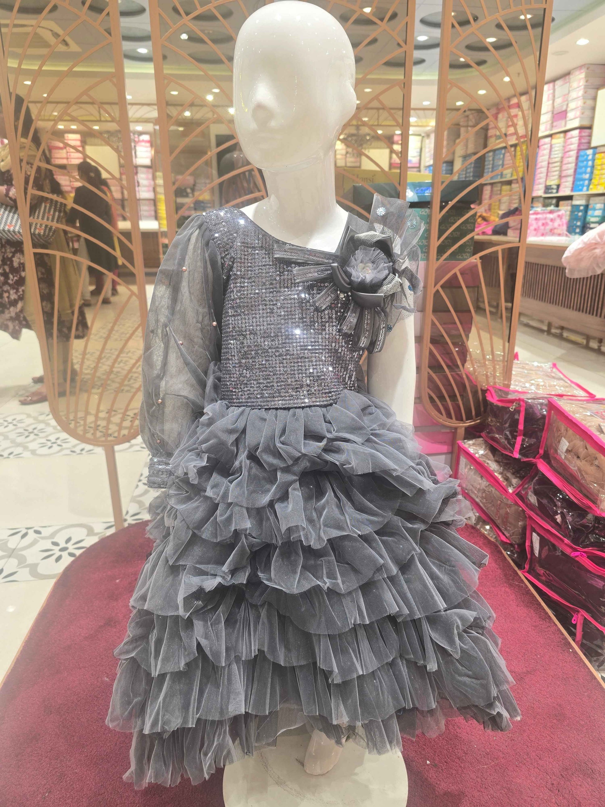 Knitted material grayish coloured short frock for baby girl with talecut pattren and sequence work over the top ,bow on left shoulder