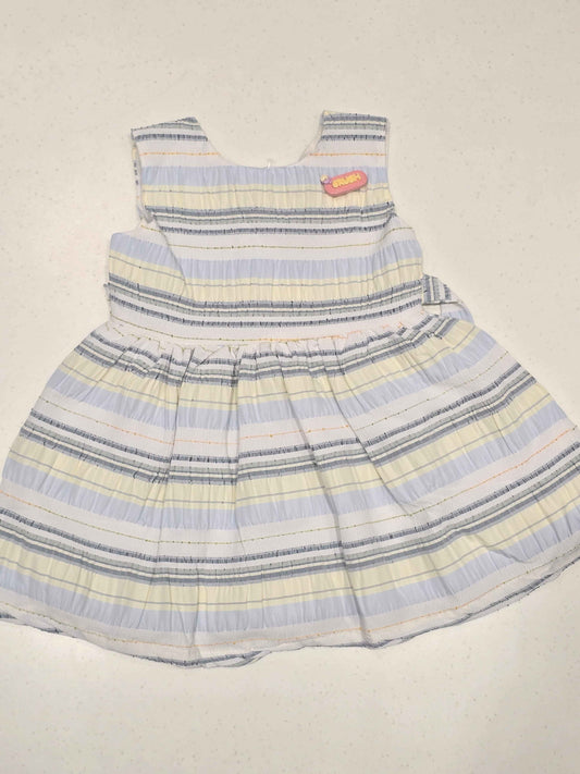 Bodice: Features an upper sleeveless cut with a rounded neckline, structured horizontal paneling, and an embroidered text patch detail on the upper left chest.