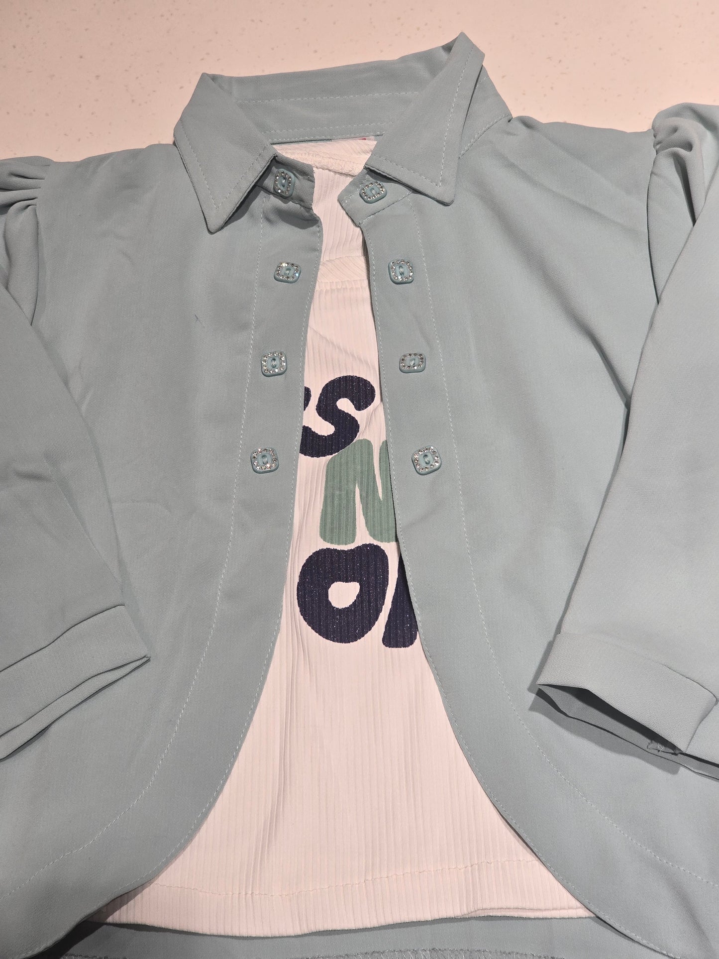 children's layered outfit set featuring an open-front light pastel blue/green overshirt jacket worn over a white graphic t-shirt.