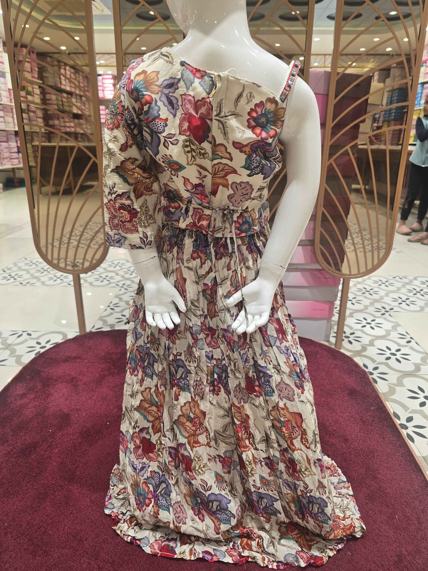 Crepe material cream based gaghra with printed floral & zari work over the body. Right shoulder with speghetti left had full sleeves